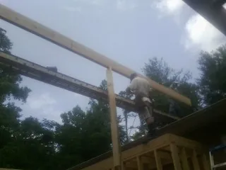Carpenter setting a ridge beam over a new addition frame — Ice Dam Removal by Roofing Brothers in South Charleston