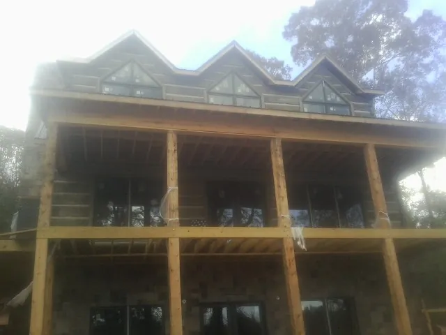 Dormers and porch framing on a large log home under construction — Roof Coating work by our crew in South Charleston