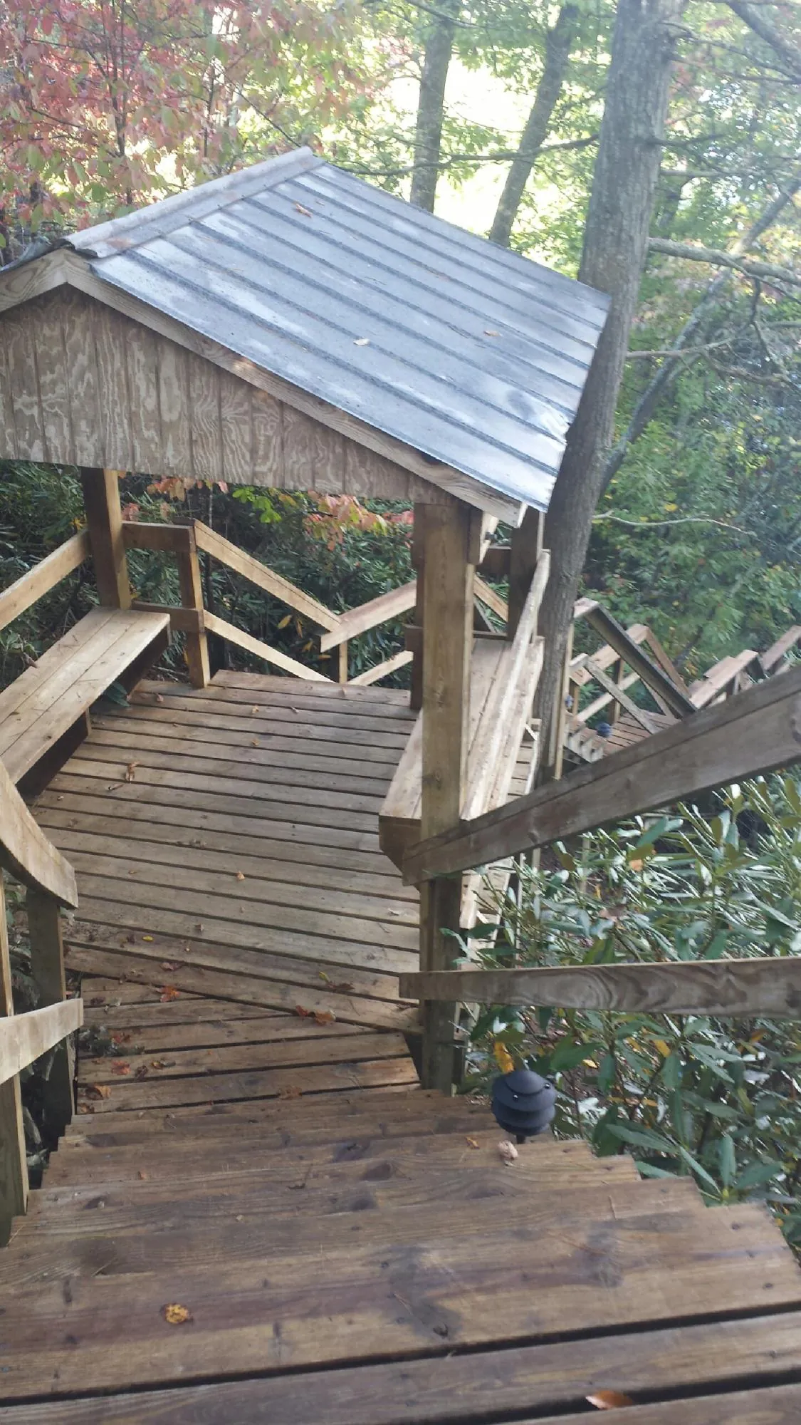 Metal roofed shelter over wooden steps on a wooded walkway — Skylight Repair & Installation work by our crew in South Charleston